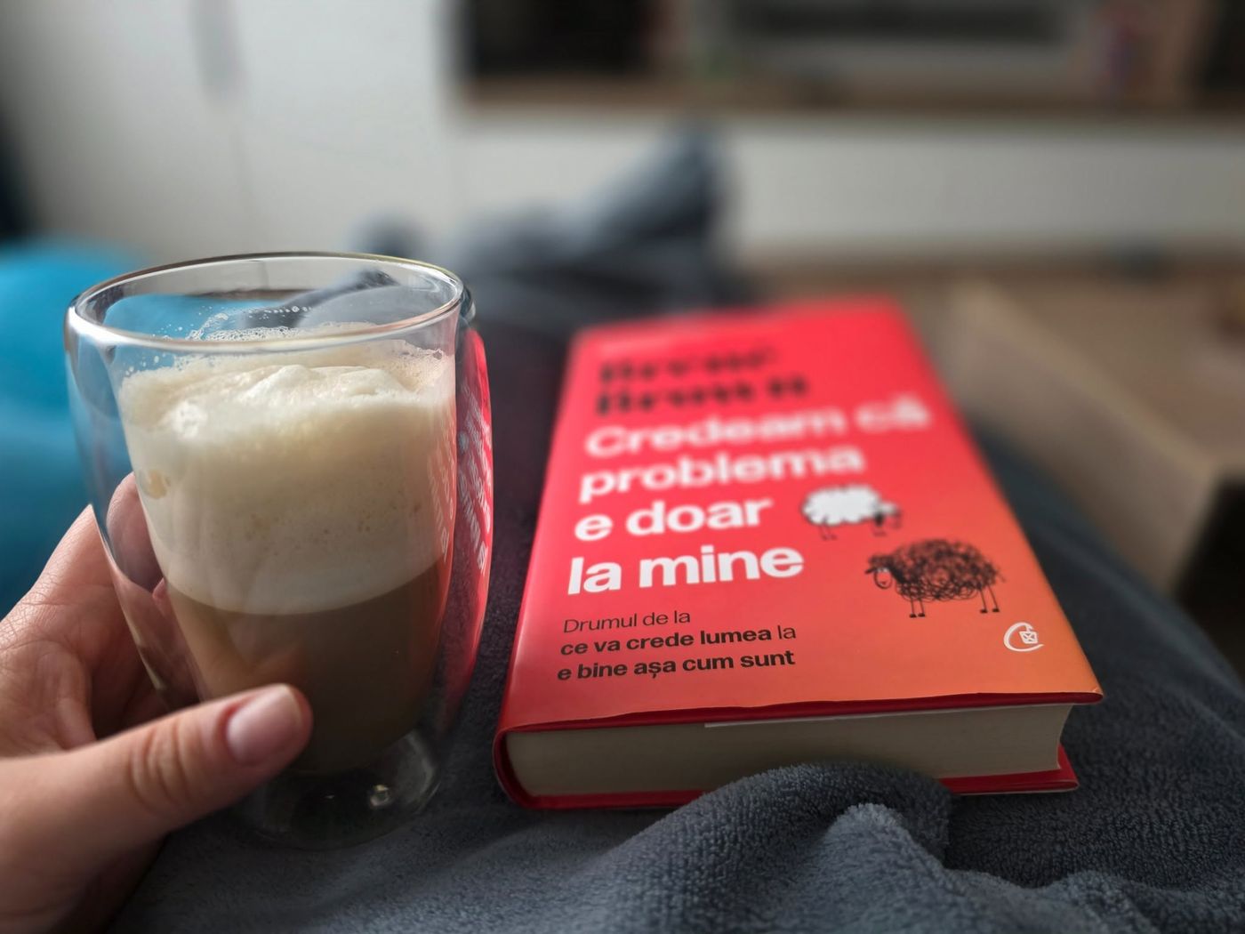 Cafea cu lapte lângă o carte deschisă