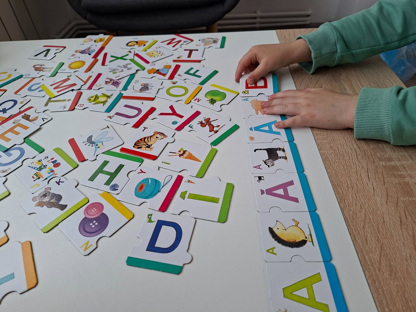 Puzzle cu literele alfabetului, lucrat împreună cu un copil